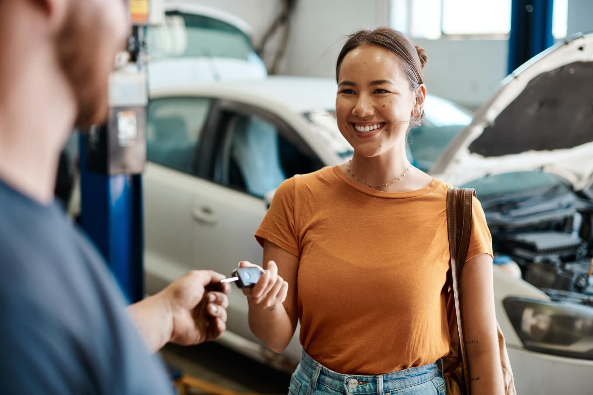 Customer handing mechanic keys to service her car