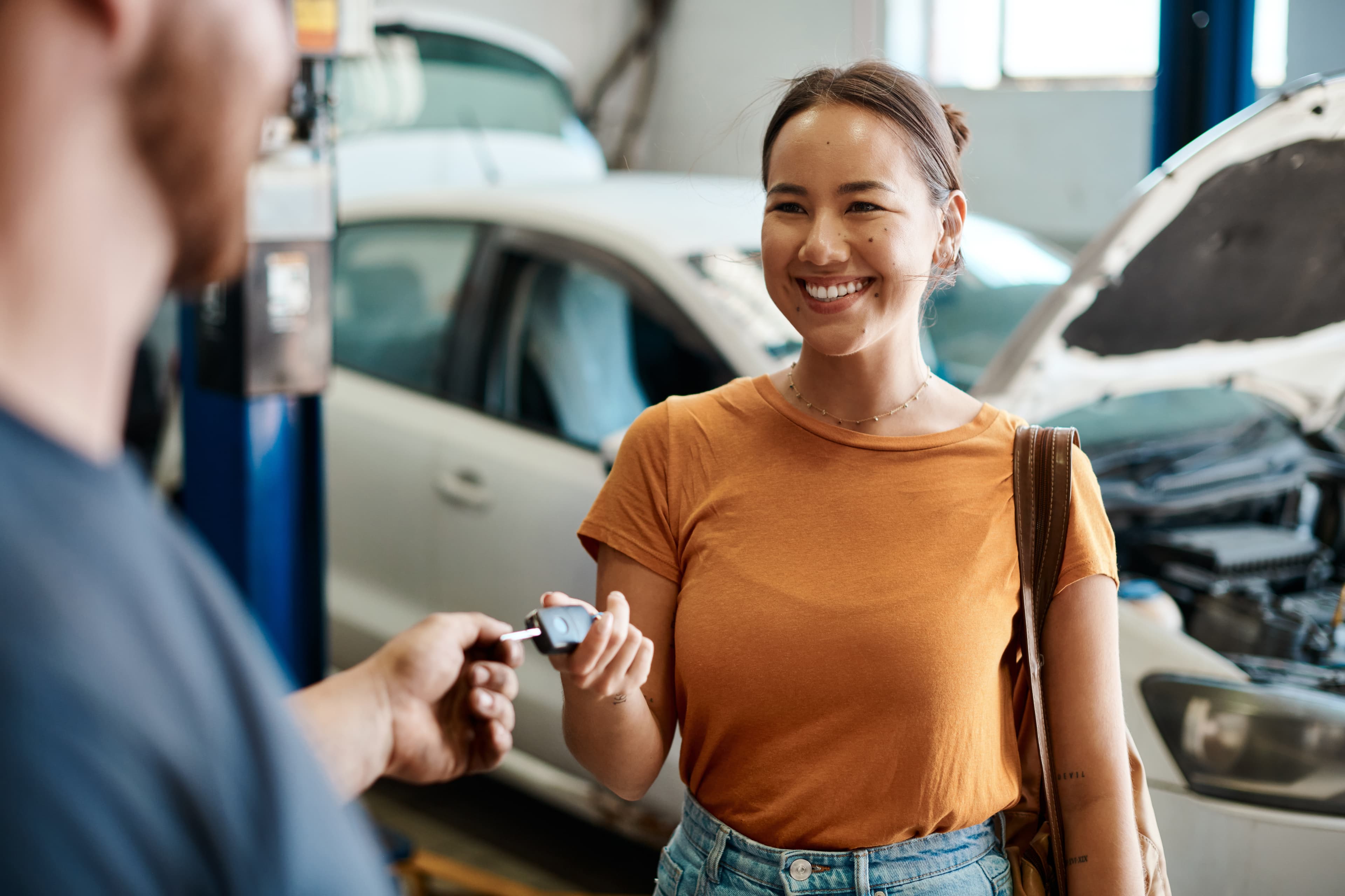 Customer handing mechanic keys to service her car