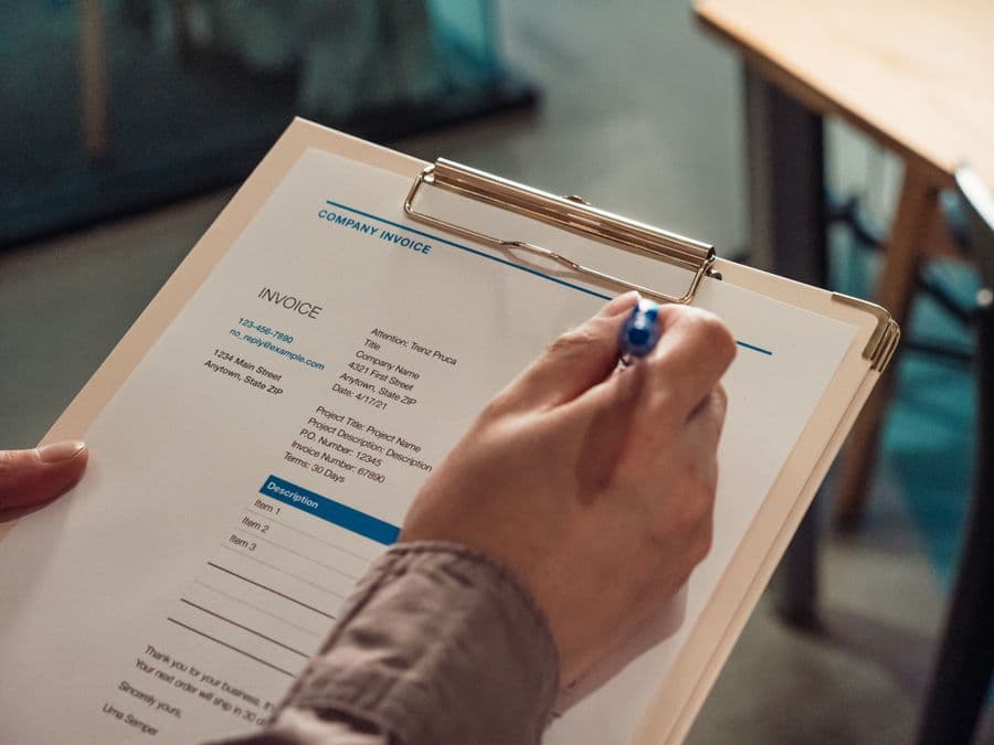Garage invoice held on a clipboard with a pen